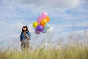 Beautiful Girl jumping with balloons on the beach photo