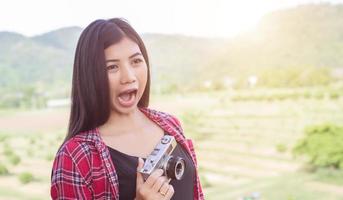 Young hipster woman photographer holding a vintage camera. photo