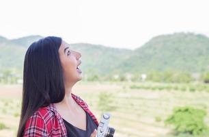 Young hipster woman photographer holding a vintage camera. photo