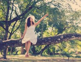 Young teen girl sitting on tree photo