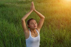 Yoga in the city beautiful young fit woman wearing sportswear meditating, breathing, sitting with crossed legs in Half Lotus Posture on the street on summer day, Ardha Padmasana, copy space photo