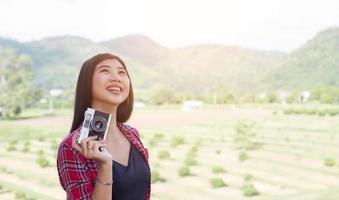 Young hipster woman photographer holding a vintage camera. photo