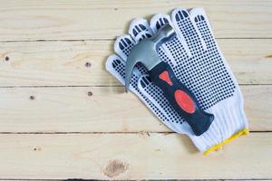 Gloves and hammer on wooden background photo