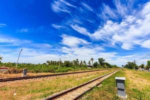 Railroad track in countryside of Thailand with beautiful blue sky