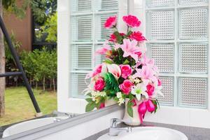 Vase of artificial flower in the bathroom photo