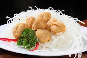 Fried meatballs. Made from catfish ball,With the addition of white fried vermicelli. parsley and red chili garnish. photo