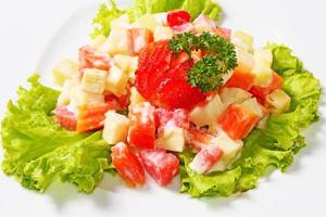 Fruit salad is a healthy snack consisting of pieces of fruit, pineapple, watermelon, papaya, strawberries, which are doused with a creamy and delicious sauce. photo