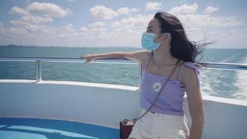 Young asian woman wear protective face mask sitting on the ship ferries deck, travel to the island, Covid19 awareness prevention, Social distancing, keep away distance, stay safe while traveling video