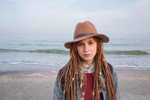 retrato de mujer joven caminando en la playa de otoño foto