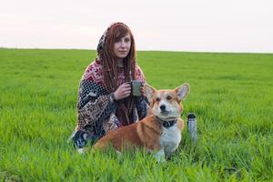 young woman with corgi in spring field