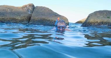 junger männlicher Schwimmer mit Schnorchelbrille taucht im Sommermeer