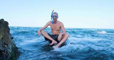 joven nadador masculino con gafas de buceo bucear en el mar de verano