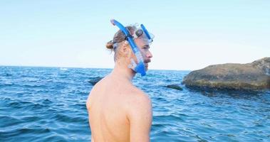 Young male swimmer with snorkling glasses dive in the summer sea video