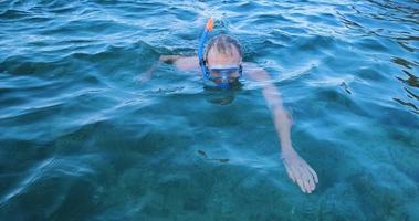 jeune nageur avec des lunettes de plongée plonge dans la mer d'été video