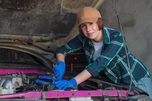 Coche de fijación mecánica femenina en un garaje foto