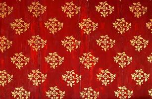 Golden flower pattern on red background. photo