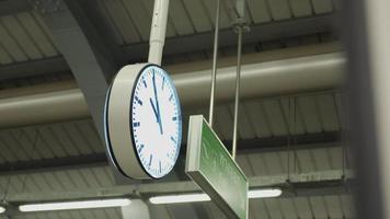 relógio da estação de trem pública, compromisso na estação, horário de pico, horário de trabalho durante a semana, relógio grande pendurado no teto da plataforma de trem, noite à noite video