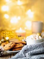 Cozy evening, cup of drink, Christmas decorations, candles and lights garlands photo