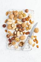 Mix of nuts - walnut, almonds, pecans, macadamia and knife for opening shell photo