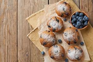 Blueberry muffin, top view, copy space. Cupcakes with berries on old rustic wooden table