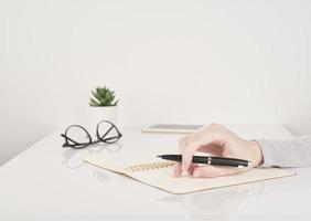 mujer escribiendo en la página del cuaderno, trabajo de oficina o concepto de estudio foto