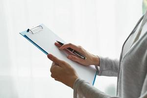 Woman holding clipboard, concept of office work or studying student side view closeup photo