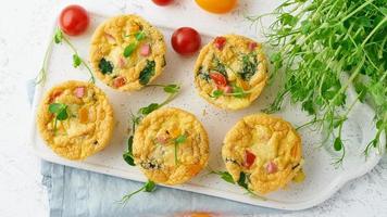 omelet with tomatoes and bacon, baked eggs with spinach and broccoli, top view, photo