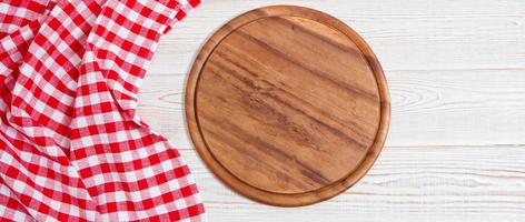 Napkin and board for pizza on wooden desk closeup, tablecloth. Canvas, dish towels on white wooden table background top view mock up. Selective focus photo