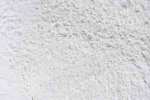 la harina cierra la textura de fondo. un montón de harina sobre un fondo blanco. harina derramada. foto