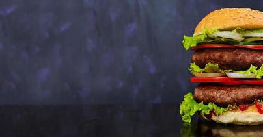 Delicious handmade burger on dark background. Banner. photo