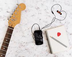 Music stuff. Guitar, guitar pedal, headphone, mobile phone on white background. Top view. Flat lay photo