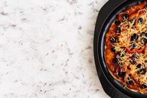 Pizza with salami, peppers, mushrooms and olives on white background. Top view photo