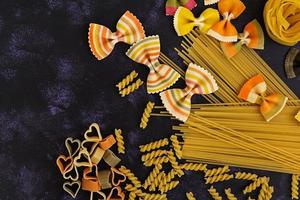 Dry pasta background. Different pasta on dark background. Flat lay. Top view. photo