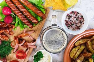 Baked potato wedges with sausages and spices. Top view photo