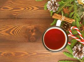 Christmas and Happy New Year background with tea. Top view, copy space. Fir branches, brown dark wooden table photo