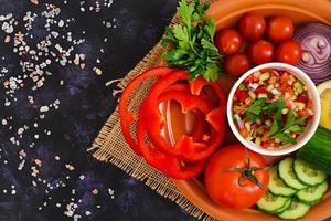 Salsa with ingredients on dark background. Top view photo