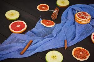 Apple, grapefruit and cinnamon on wooden background. Ingredient for hot mulled wine. Top view