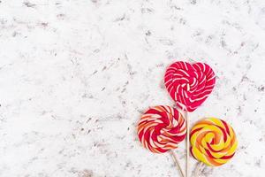 Colorful lollipops on white background. Top view photo