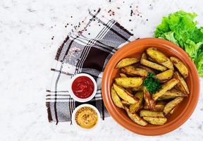 Baked potato wedges with spices. Top view photo