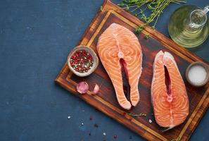 dos filetes de salmón, filete de pescado, grandes porciones en rodajas en una tabla de cortar foto