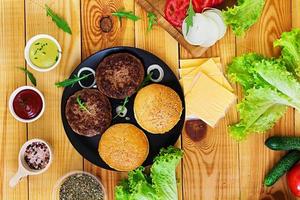 Ingredients for burger on wooden background. Top view photo