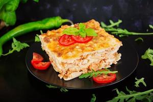 Classic Lasagna with bolognese sauce on dark background photo