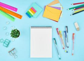 Office supplies, stationery on blue office desktop. Top view of modern bright table
