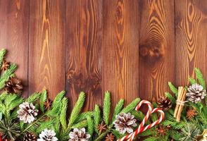 navidad y feliz año nuevo fondo marrón oscuro. vista superior, espacio de copia, mesa rústica de madera, ramas de abeto