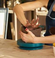 Woman making ceramic pottery, hands closeup, focus on potters, palms with pottery