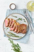 Keto ketogenic diet beef steak, striploin on gray plate on white background. Paleo food recipe
