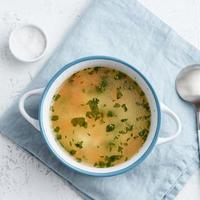 sopa de pollo, comida casera escandinava con mesa de piedra azul, vista superior foto