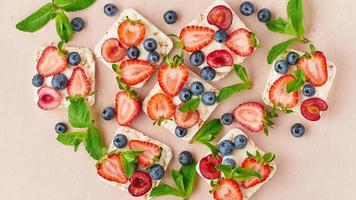 Rise crispbread with berries and fruits colorful concept on terracotta background closeup top view photo