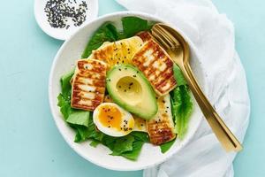 keto ketogenic diet soft boiled eggs with avocado and lettuce on pastel background closeup top view photo