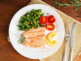 Fish salmon steamed with vegetables. Healthy diet food, dark wooden backdrop photo